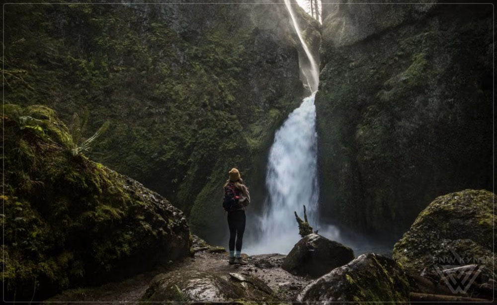 Best Waterfalls in Washington State - Hiker looking at a waterfall - PNW Life Header Image