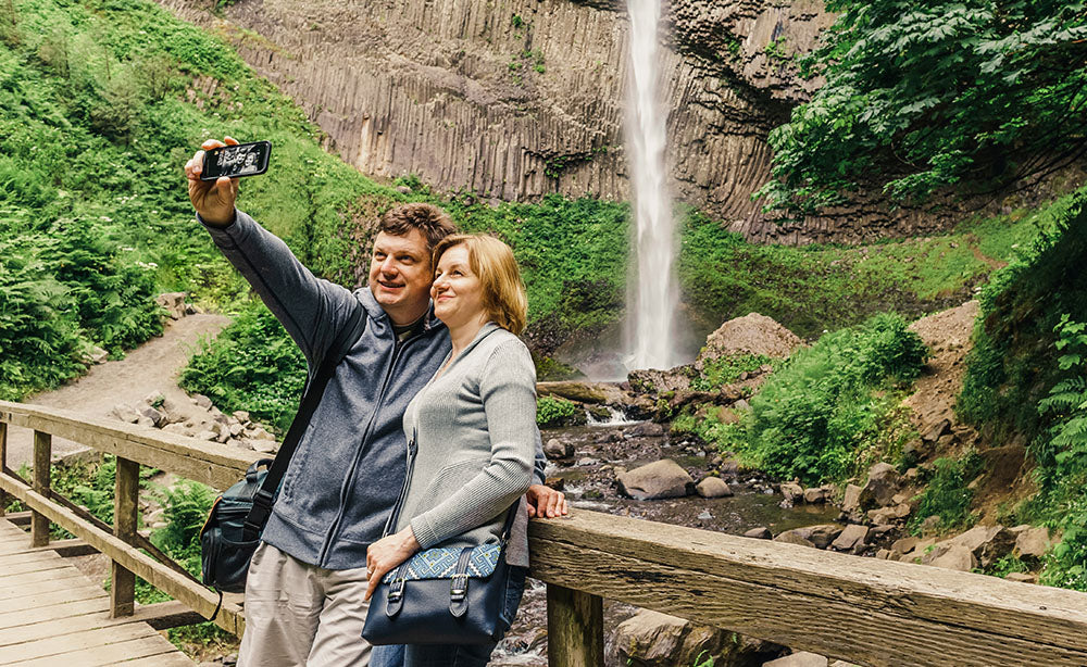 6 Things to do in the Pacific Northwest - Man and woman on a bridge taking a photo - PNW Life Header Image