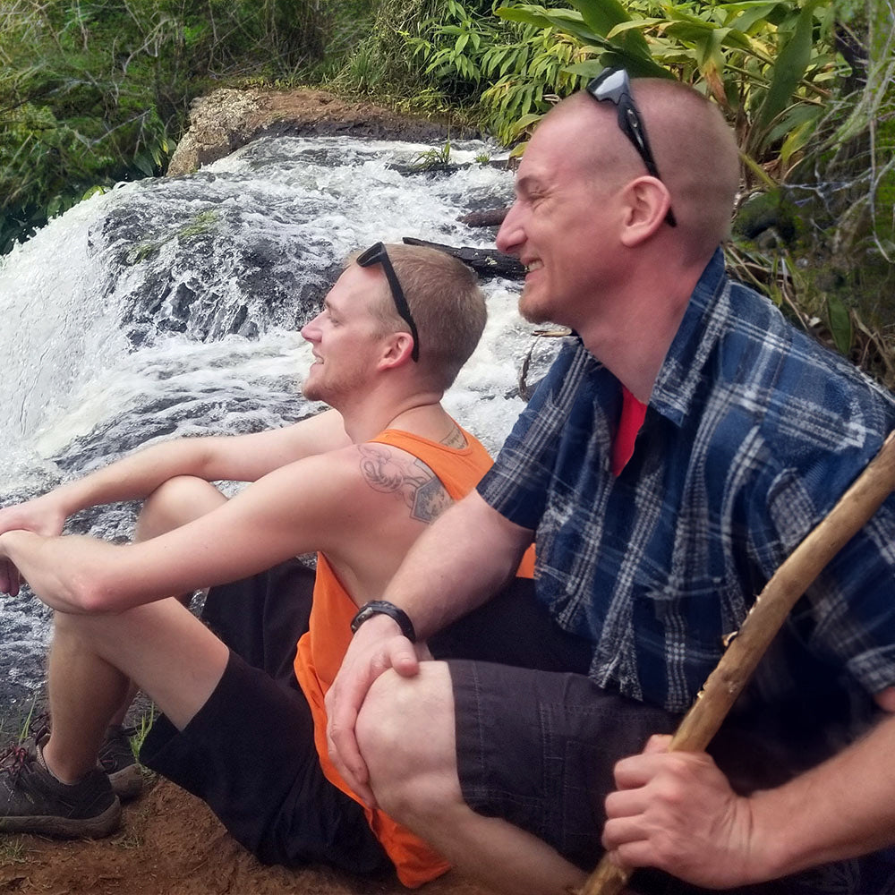 Joe Buchmann and Garrett Busch hiking by a waterfall