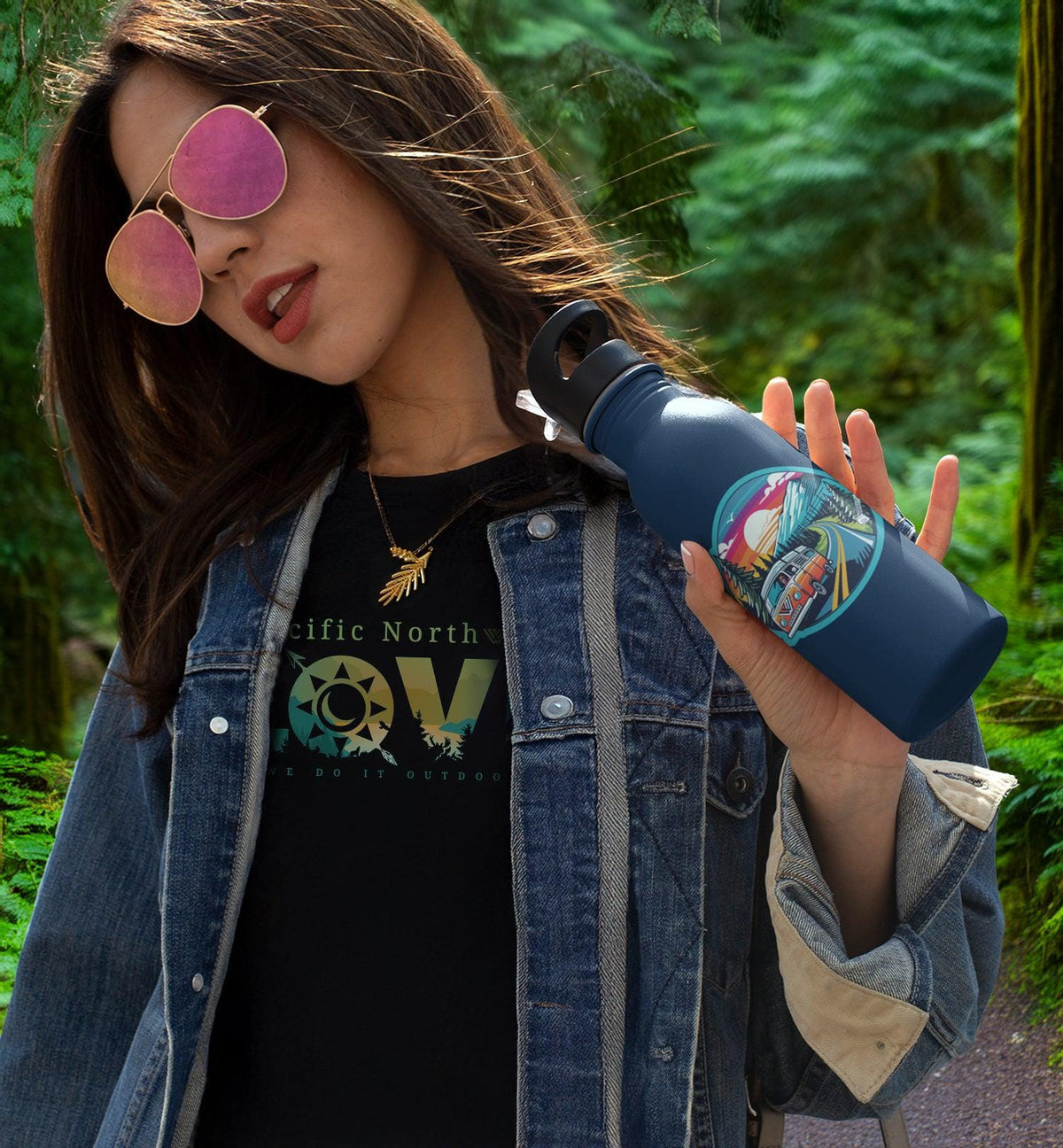 Woman holding water bottle displaying PNW Highway sticker on a blue water bottle, set in a Pacific Northwest background.