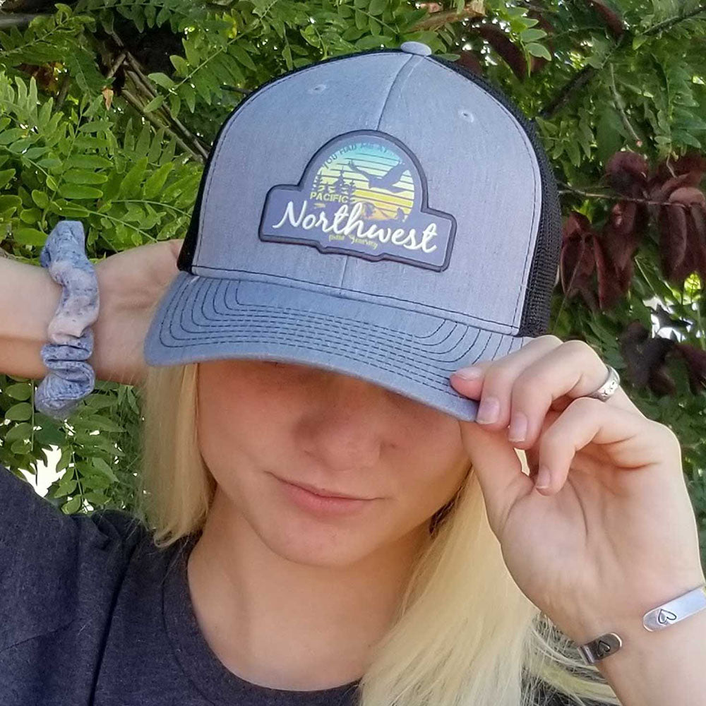 Girl showing off PNW Sunset trucker hat