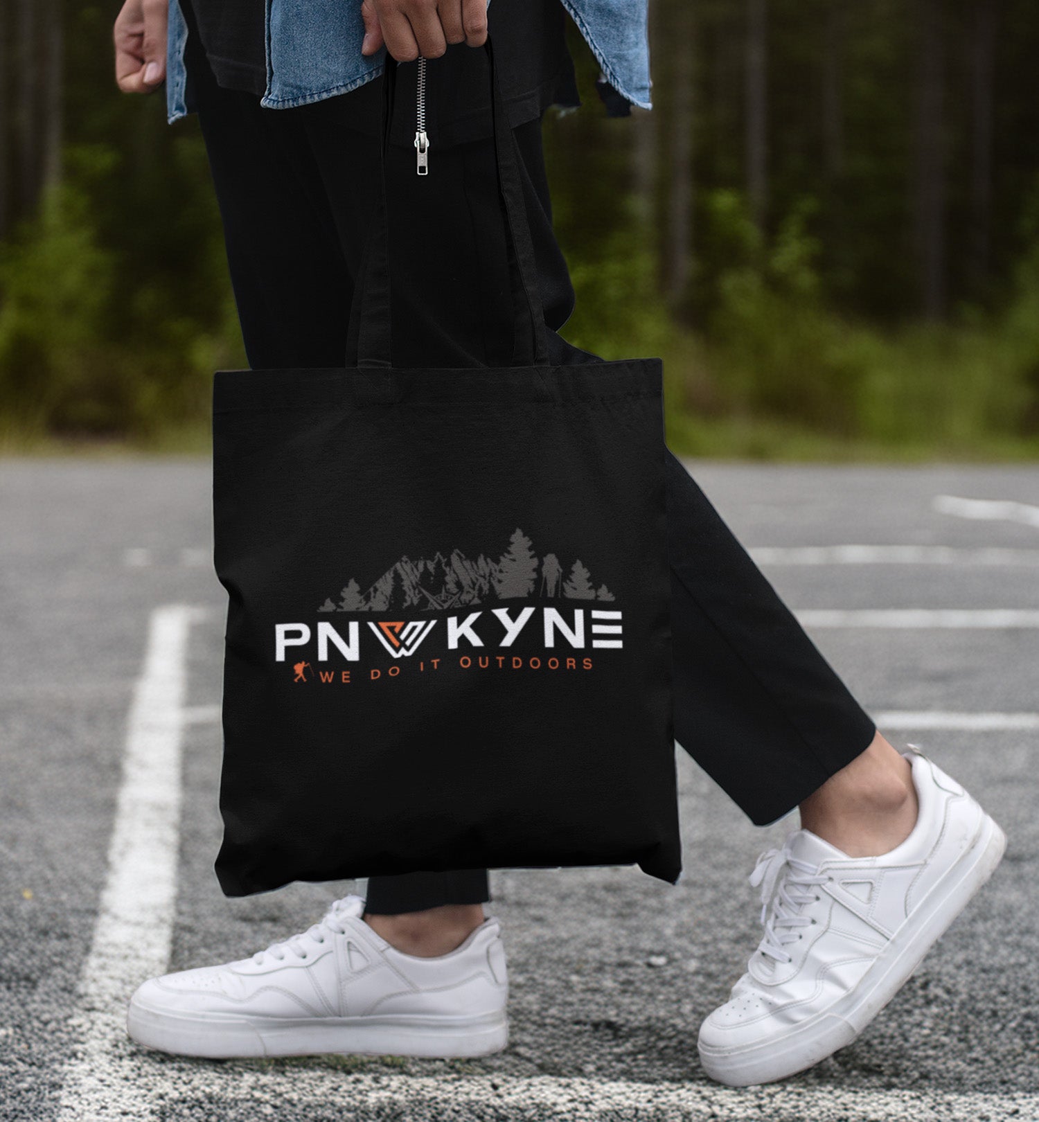 PNW KYNE Classic Tote Bag in a parking lot by the forest