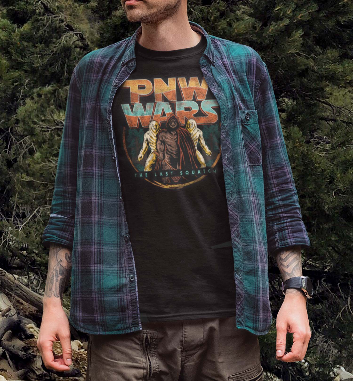 Man wearing a PNW Wars Last Squatch shirt in the Pacific Northwest forest